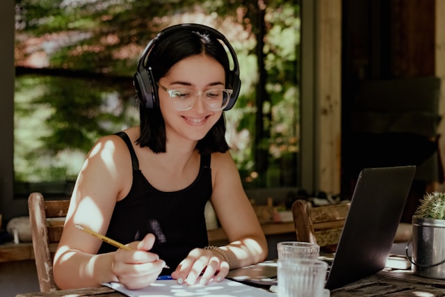 Teen working on homework with headphones on