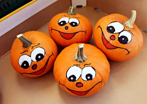 Painted pumpkins in a produce box.