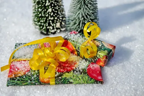 Two brightly wrapped gifts in the snow. 