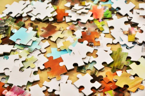 Puzzle pieces scattered on a table. 