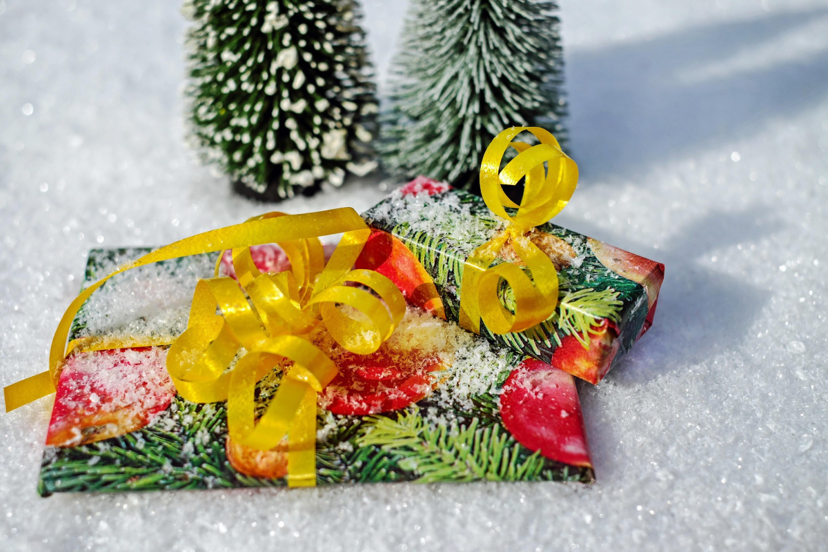 Two brightly wrapped gifts in the snow. 