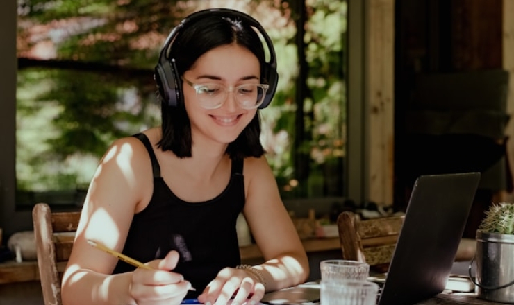 Teen working on homework with headphones on